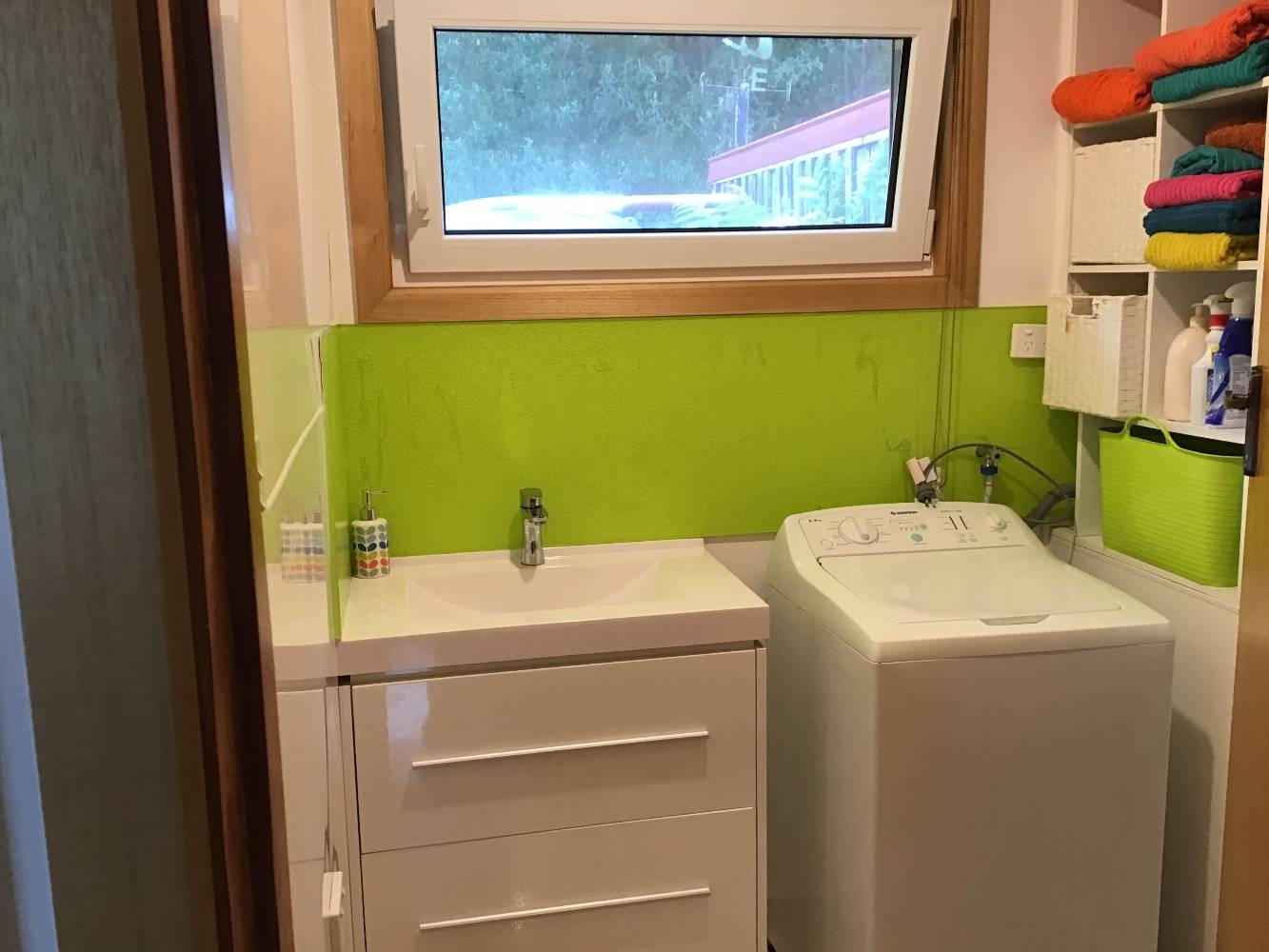 Bathroom with washing machine.  Shower is to the right