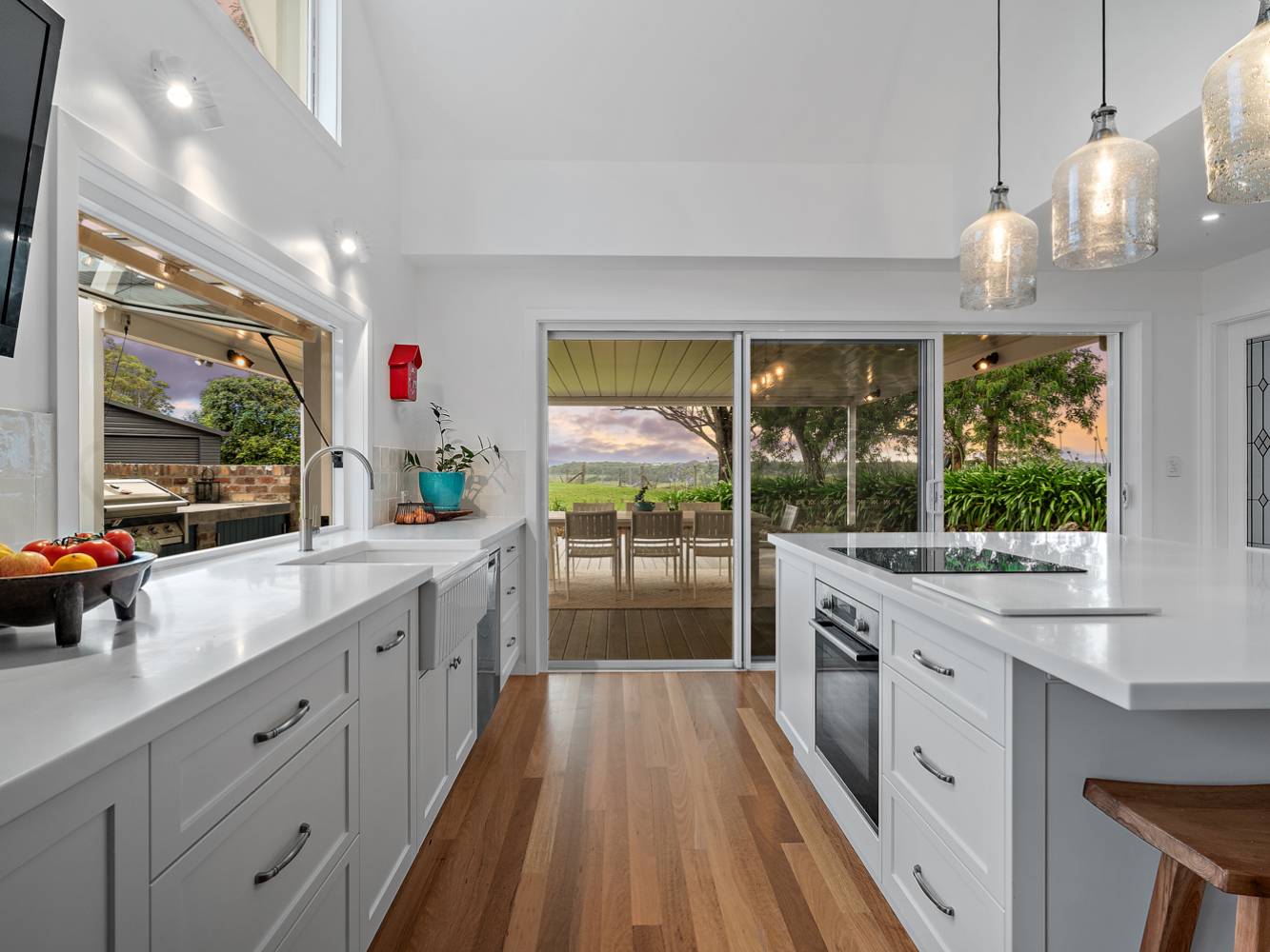 Beautiful new kitchen, with enormous island, conduction stove-top, corian benches, double farmhouse sink, gas-lift window on the left to the side deck, glass sliding doors to the back deck