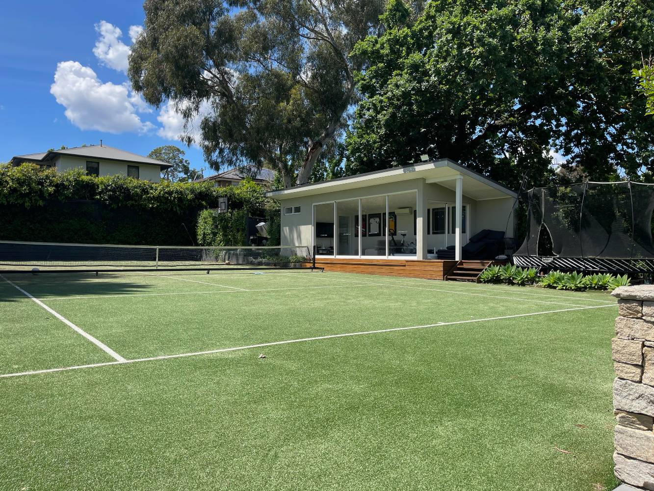 Tennis court (with basketball and netball rings) and cabana/gym